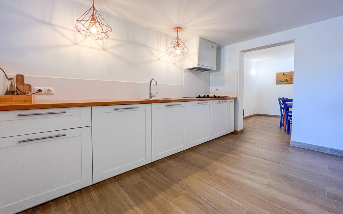 Modern open kitchen with white cabinets and a gas stove